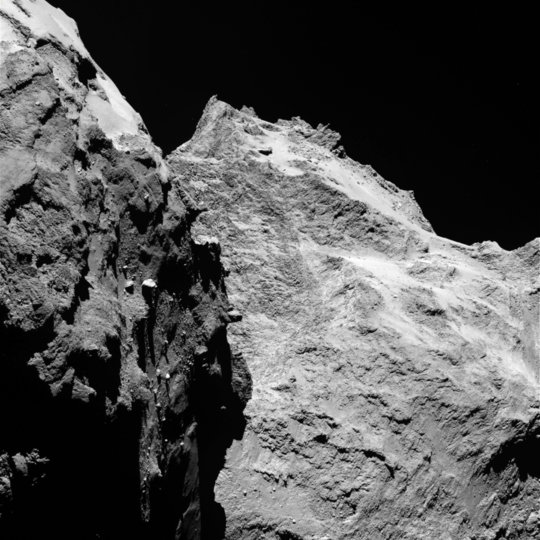 Jagged cliffs and prominent boulders: In this image, several of 67P’s very different surface structures become visible. The left part of the images shows the comet’s “back”, while the right is the back of its “head”. The image was taken by OSIRIS, Rosetta’s scientific imaging system, on September 5th, 2014 from a distance of 62 kilometers. One pixel corresponds to 1.1 meters. <br /><br />