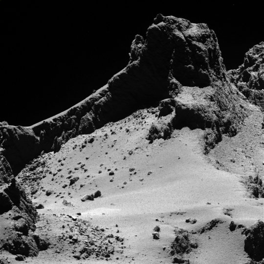 Eine Landschaft auf dem Kopf, dem kleineren Teil des Kometen 67P/Churyumov-Gerasimenko. Das Bild wurde vom wissenschaftlichen Kamerasystem OSIRIS an Bord der ESA-Raumsonde Rosetta am 14. Oktober 2014 aus einer Entfernung von etwa 8 Kilometern von der Oberfläche aufgenommen. Die räumliche Auflösung beträgt 15 Zentimeter pro Pixel. <br />Das Bild ziert die Titelseite der Ausgabe des Fachmagazins Science vom 23. Januar 2015.