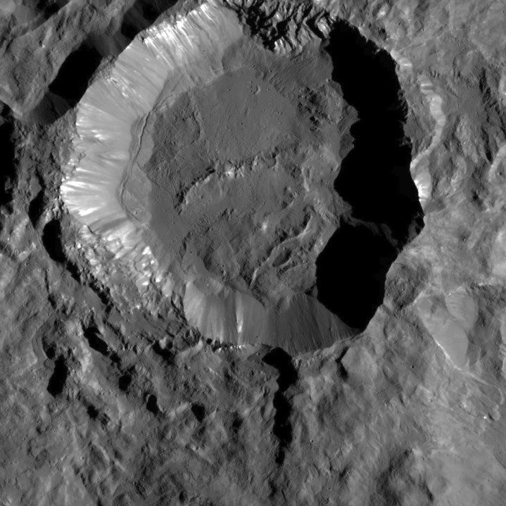 <p>Der Krater Kupalo (Durchmesser etwa 25 km). Die noch sehr scharfen wenig verwitterten Oberflächendetails insbesondere am Kraterrand deuten auf ein geringes Alter dieses Kraters hin. Bei den hellen Flecken handelt es sich wahrscheinlich um Salzablagerungen, die aus unterirdischem Eis freigesetzt wurden.</p>
