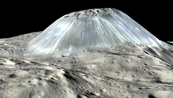 Der Vulkan Ahuna Mons auf Ceres in einer zweifach überhöhten perspektivischen Ansicht. Die hierfür verwendeten Farbaufnahmen wurden im Juni 2016 mit der Dawn Framing Camera aus einer Höhe von 385 Kilometern aufgenommen. Die Bildauflösung beträgt 35 Meter pro Bildpunkt. Verwendete RGB-Farben: R = 960 nm, G = 750 nm, B = 440 nm. Bei Ahuna Mons handelt es sich um den Kegel eines Eisvulkans.