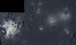 Falschfarben-Mosaik von Teilen des Occator Kraters aus Aufnahmen, die aus einem Abstand von 375 Kilometern entstanden. Links unten im Bild ist die zentrale Senke zu sehen, die das hellste Material auf dem Zwergplaneten Ceres enthält. Sie misst 11 Kilometer im Durchmesser und ist zum Teil von steilen, gezackten Bergen umgeben. In der Mitte der Senke ragt eine Kuppe 400 Meter empor, die von Rissen durchzogen ist. Ihr Durchmesser beträgt 3 Kilometer. In der rechten Bildhälfte zeigen sich weitere, deutlich blassere helle Flecke im Occator Krater.
