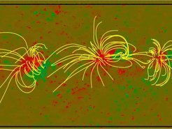 The figure shows a nonlinear force-free coronal magnetic field model (yellow lines) for 3 connected active regions. Shown in red (positive) and green (negative) is the vertical photospheric magnetic field.