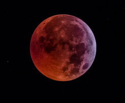 Bei einer partiellen Mondfinsternis schiebt sich die Erde zwischen Mond und Sonne. Ein Teil des Mondes erscheint dadurch rötlich-braun verfärbt.