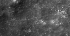 Example of an approximately 13 meter wide lunar rockfall in Nicholson Crater that has detached from a cliff (on the right) and rolled downslope for almost one kilometer (towards the left). Numerous other smaller rockfalls can be seen in the immediate vicinity.