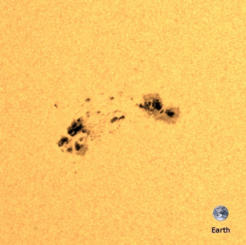 Solar active region as seen by the Helioseismic and Magnetic Imager on board the NASA Solar Dynamics Observatory. The dark circular regions are sunspots; these regions of strong magnetic field are dark as they are cool. The image of Earth is shown for scale. Credit: MPS. The HMI data were used courtesy of NASA/SDO and the HMI science team and processed at the German Data Center for SDO (GDC-SDO), funded by the German Aerospace Center (DLR).
